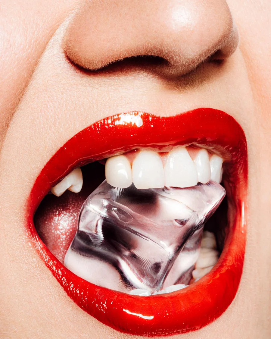 Beauty-Nahaufnahme: rote Lippen mit Eiswürfel